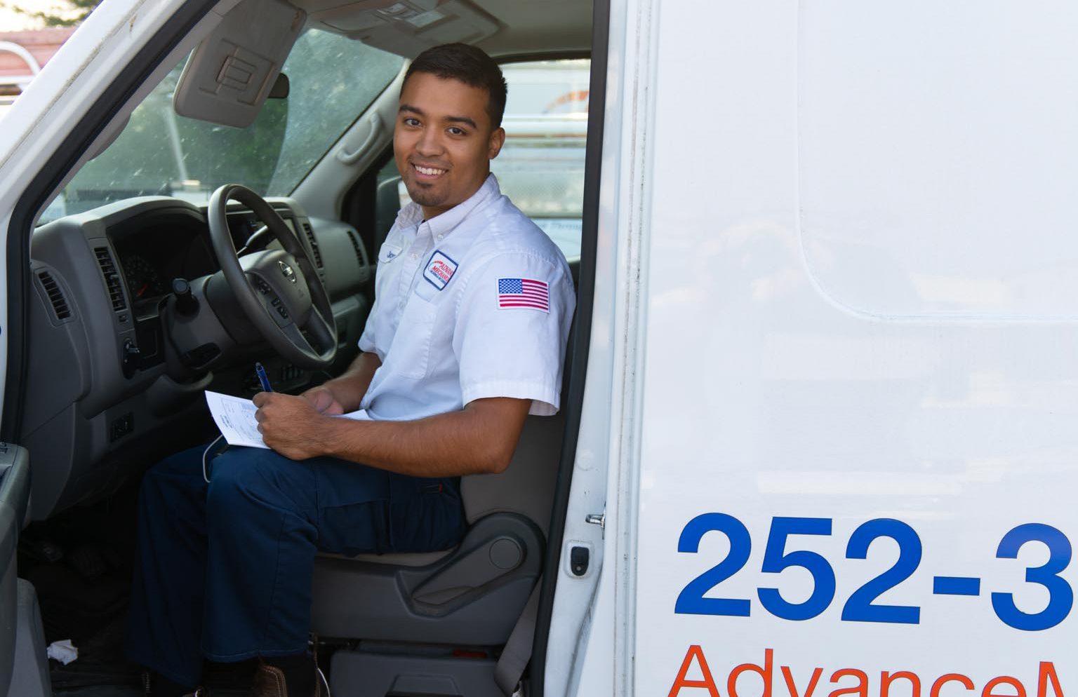 HVAC technician in truck smiling