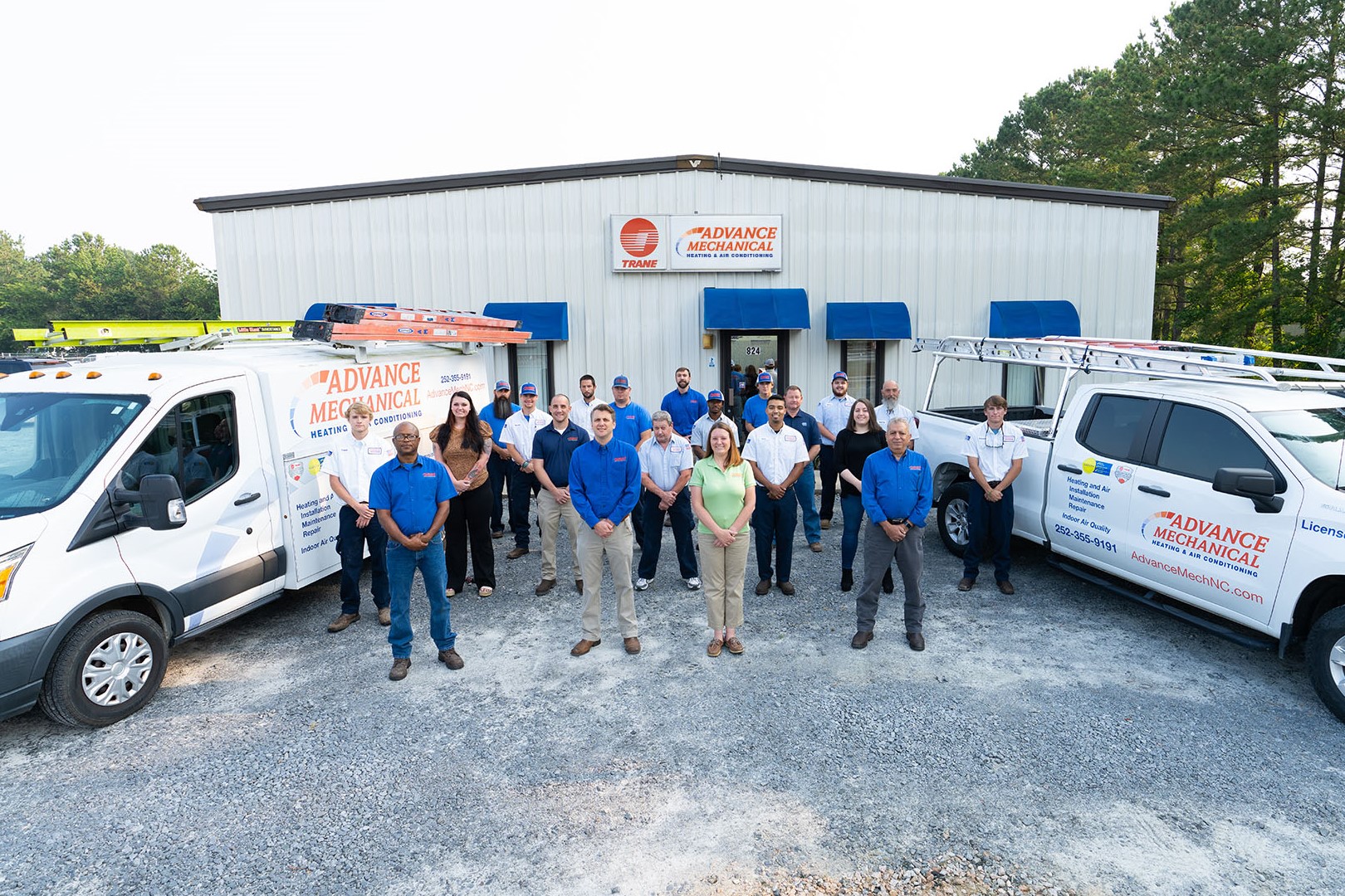 group picture of Advance Mechanical team in front of business and trucks