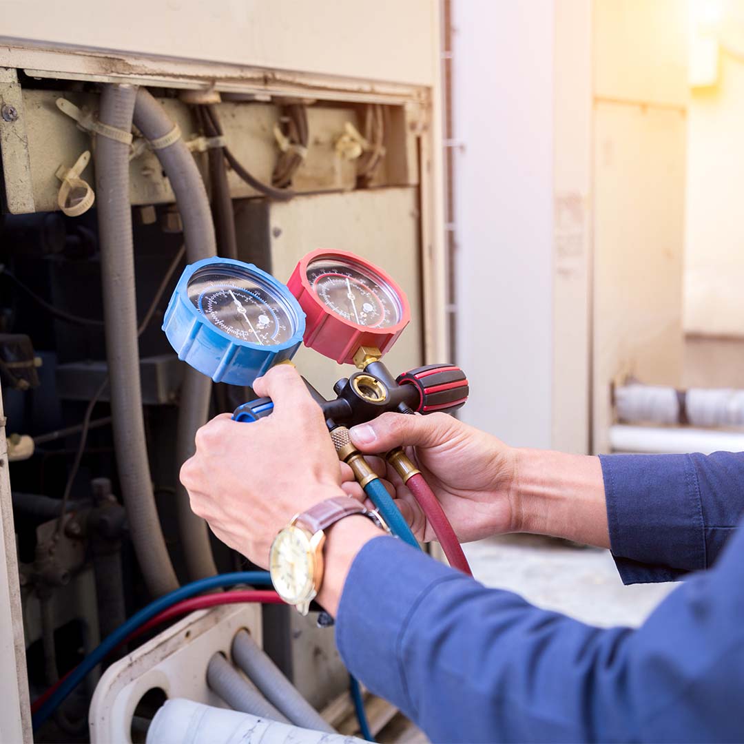 Person checking HVAC unit with meter gauge